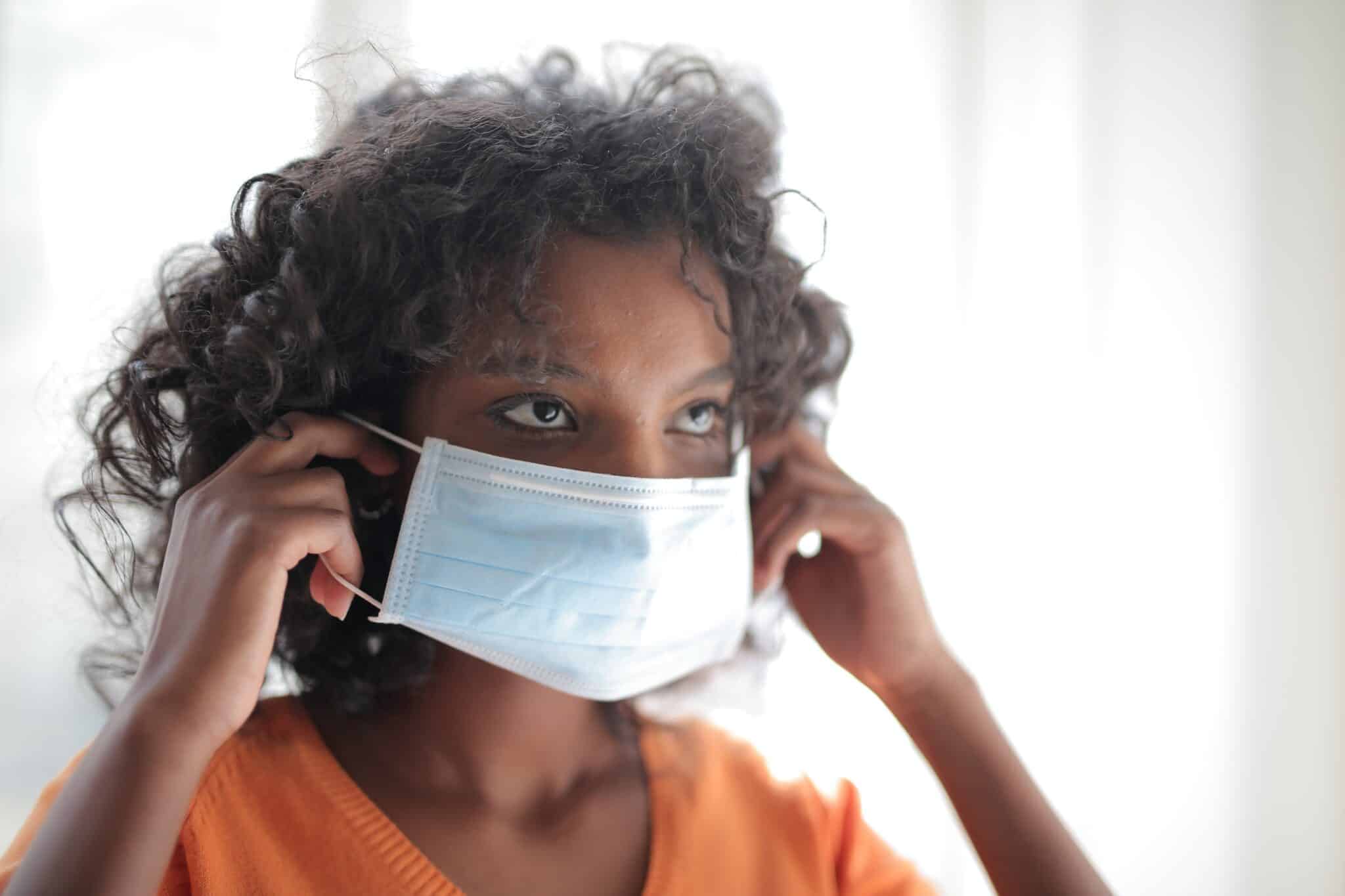 woman putting on a face mask