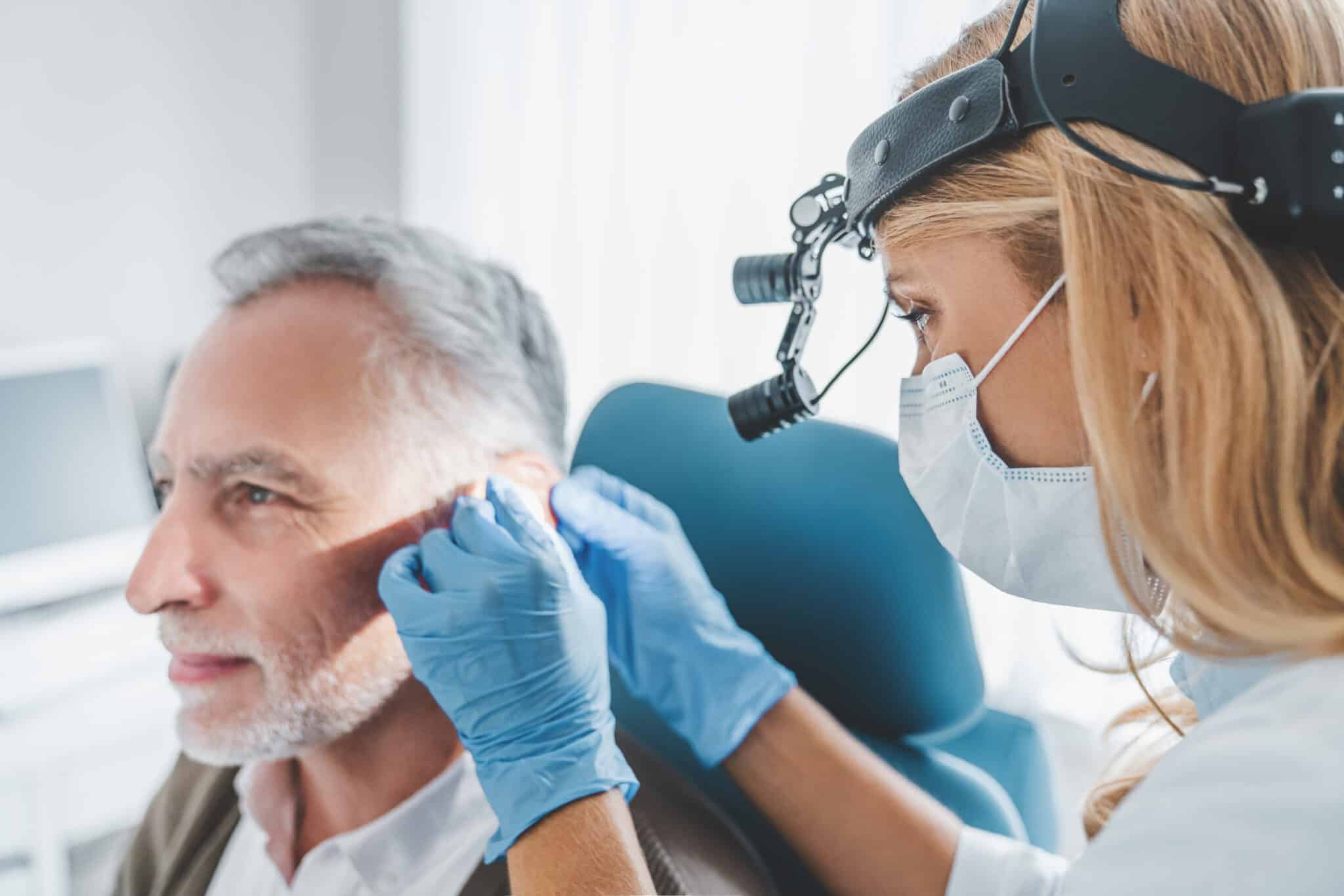 Man getting his ears examined by a medical professional.