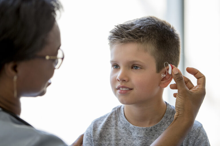 Young boy wears a hearing aid Young boy wears a hearing aid