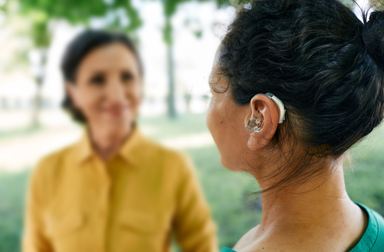 Woman with hearing aid in park