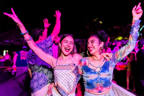Happy young women enjoying an outdoor night concert.